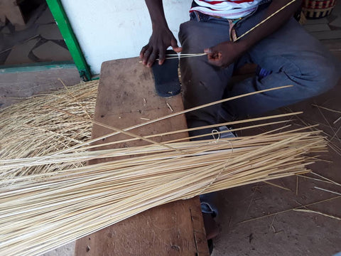 Man splitting grass before weaving basket