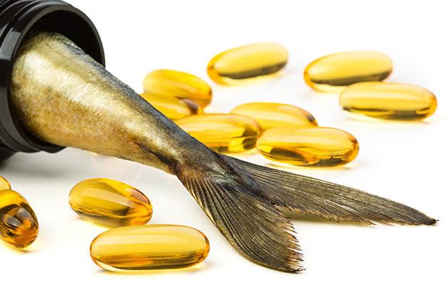 Fish oil capsules and fish tail in brown jar