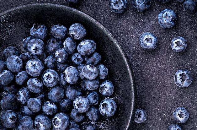 fresh picked blueberries on black stone background