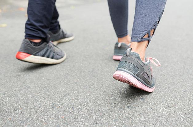 Feet of sportsmen walking on a road after training outdoors, selectve focus