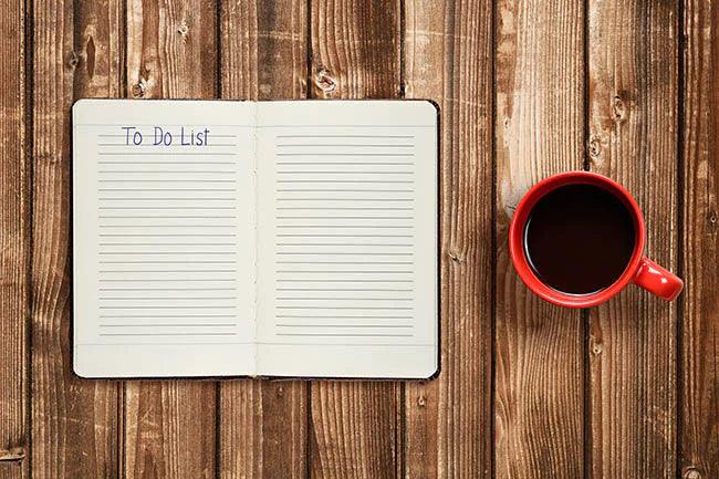To do list on diary and coffee cup on wooden table