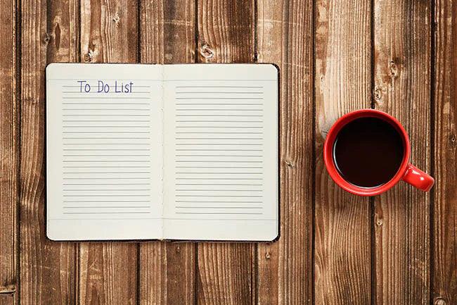 To do list on diary and coffee cup on wooden table