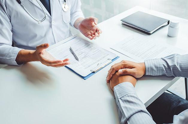 Doctors and patients consulting and diagnostic examining sit and talk. At the table near the window in the hospital medicine concept