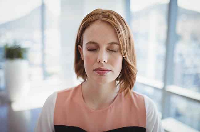 Close-up of beautiful executive meditating in office