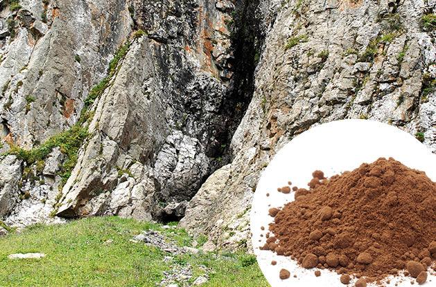 refined and purified shilajit powder overlapping the rocky surface it comes from