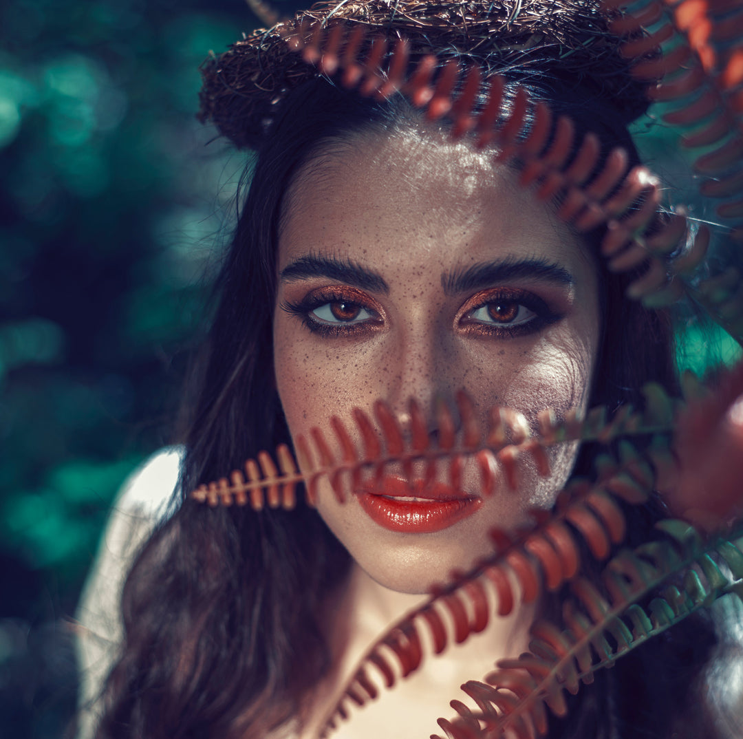 a Woman's Face with Laminated Brows behind Leaves