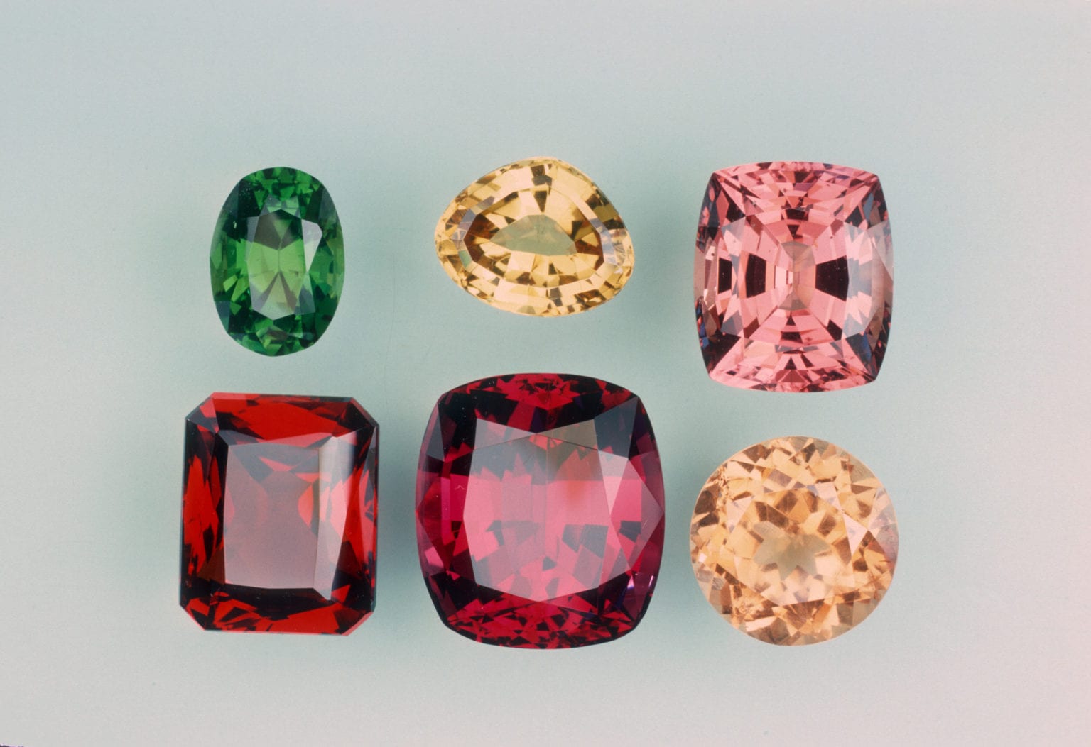Six garnet gemstones in a variery of colours.