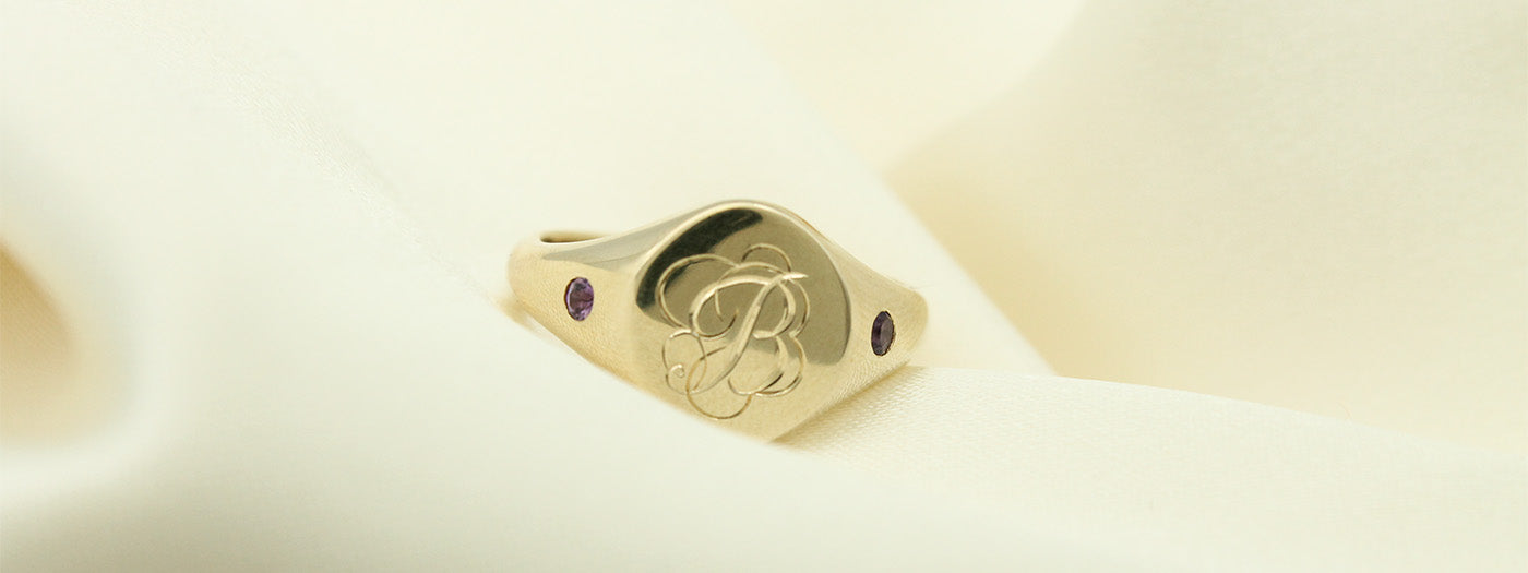 Hand engraved, custom gold signet ring with Amethyst set in the band.