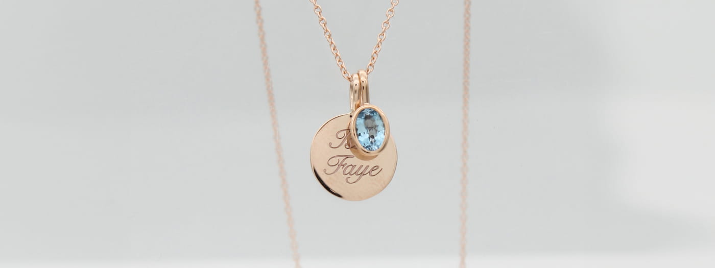 Beautiful disc pendant with custom name engraving accompanied by a tube Aquamarine pendant, both in rose gold.