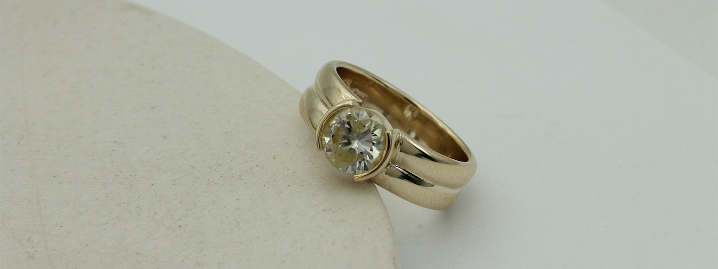 Custom diamond ring with diamond set in a minimal yet chunky yellow gold band.