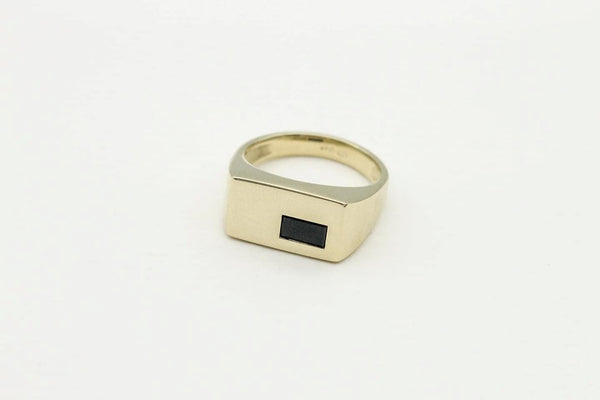 Custom gold signet ring with gemstone inlay.
