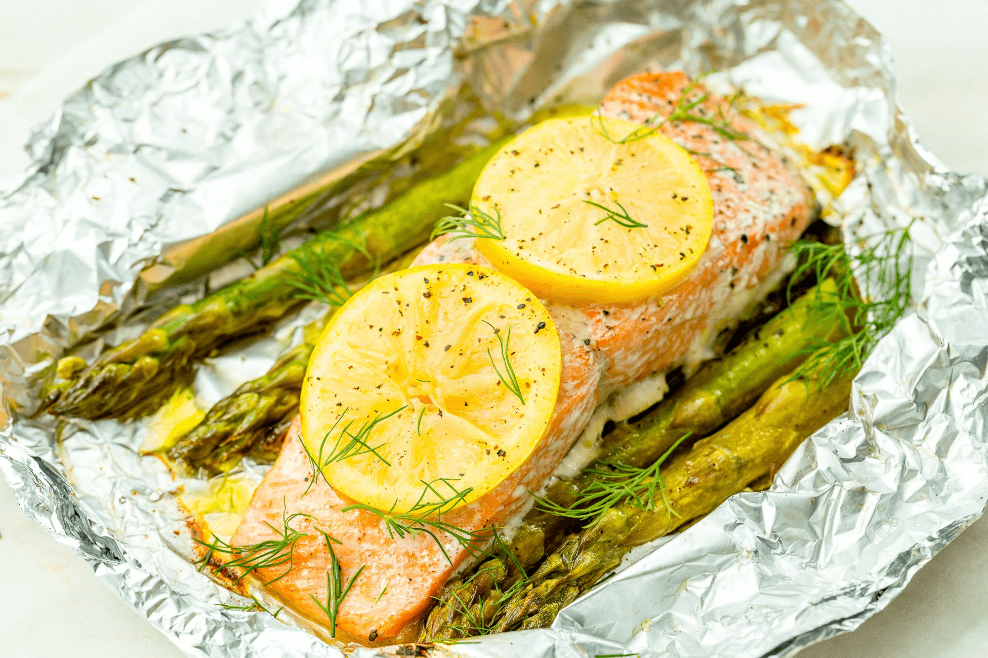 grilled salmon with lemon wedges and asparagus in foil