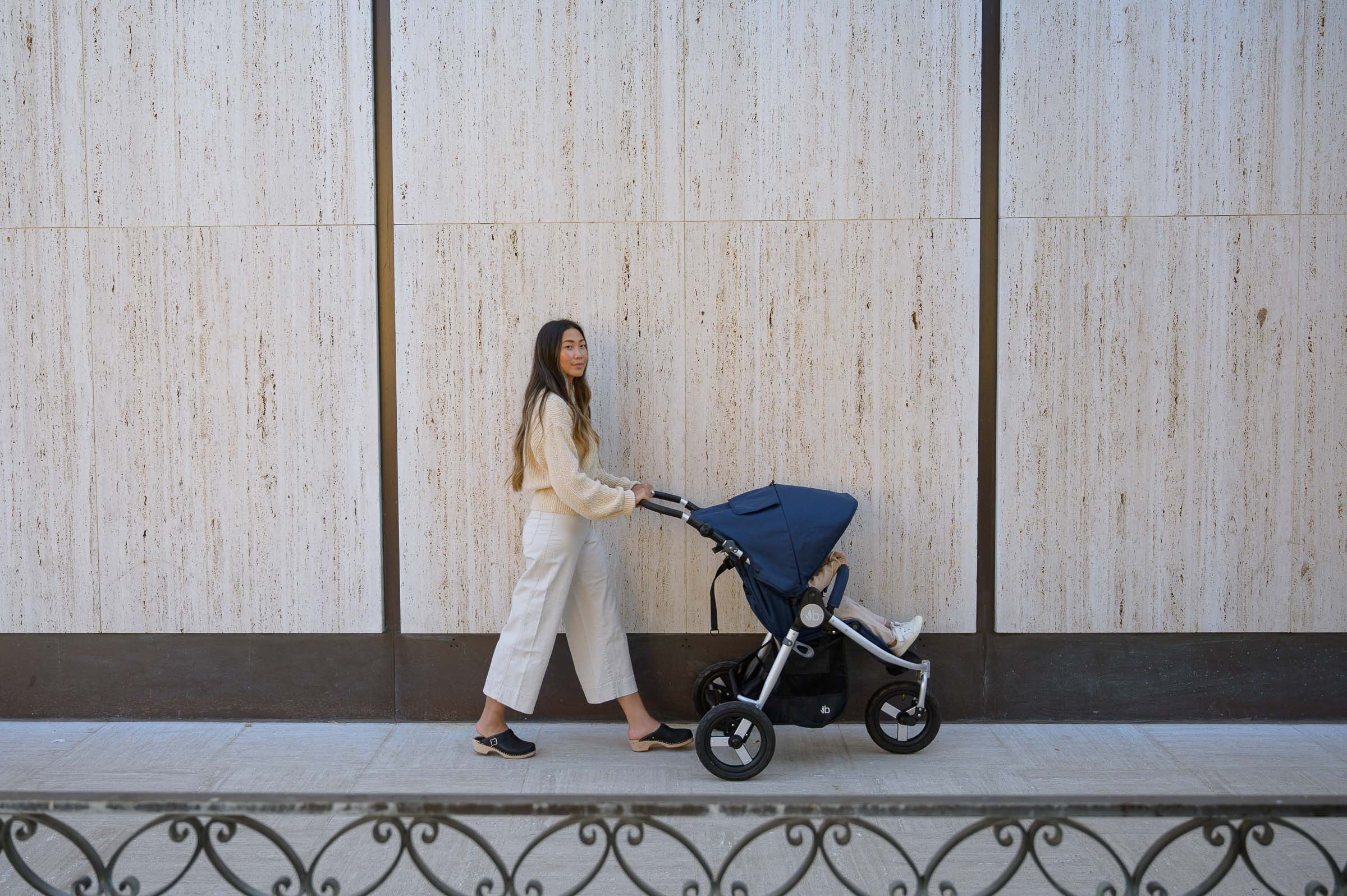 Mother pushing Indie in Maritime Blue in front of white marble walls