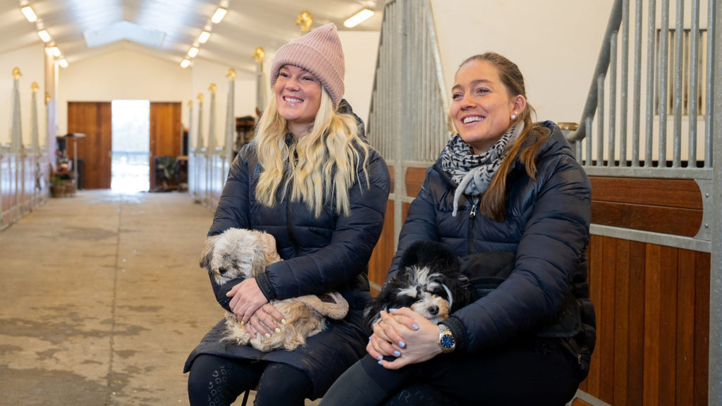 Rasmine Laudrup og Cathrine Dufour har deres hunde på skødet i stalden