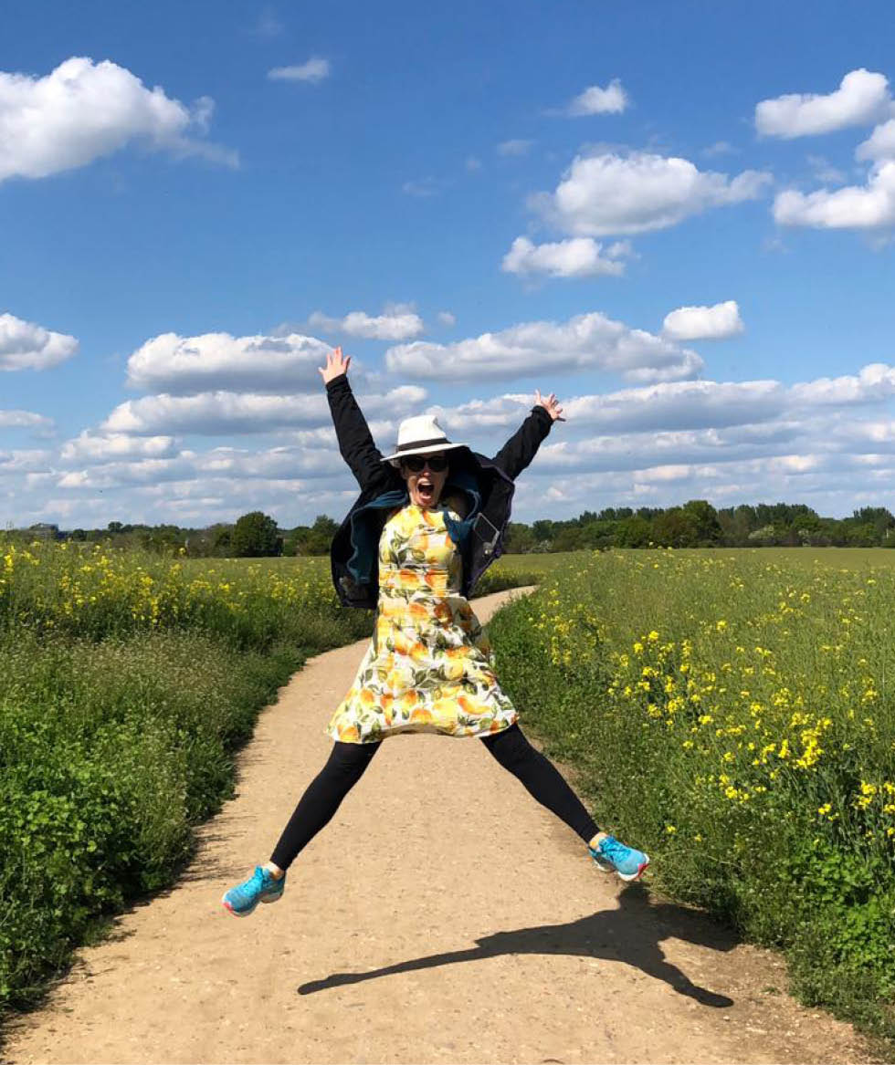 Tara Button leaping for joy in an English country field.