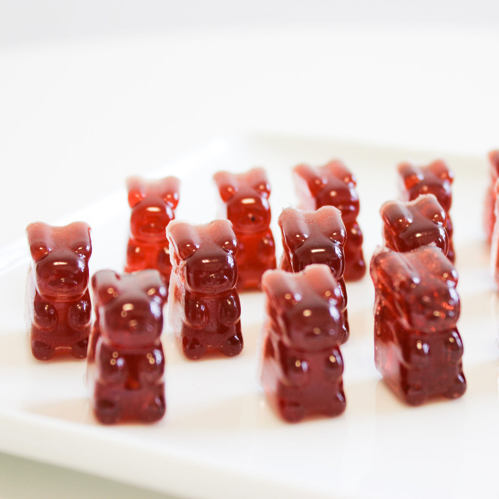 Gummy bears standing up on a white plate. 