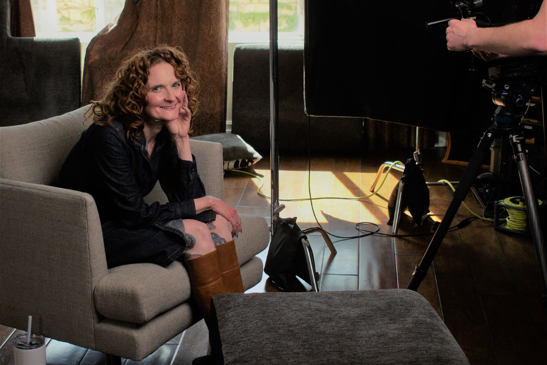 Photo of Jessica McGuinty sitting on chair behind video camera.