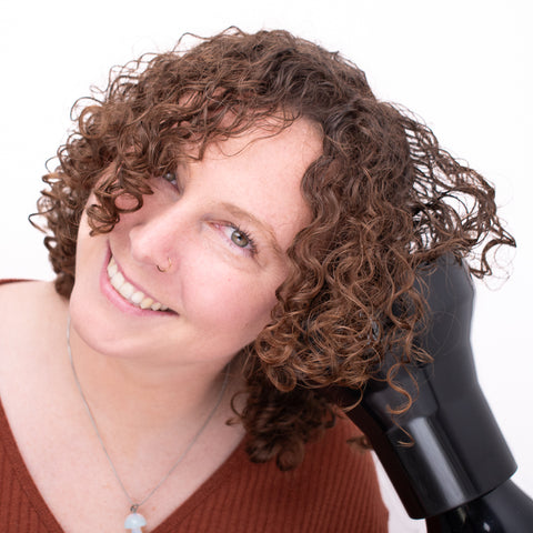 smiling curly haired woman diffusing her hair