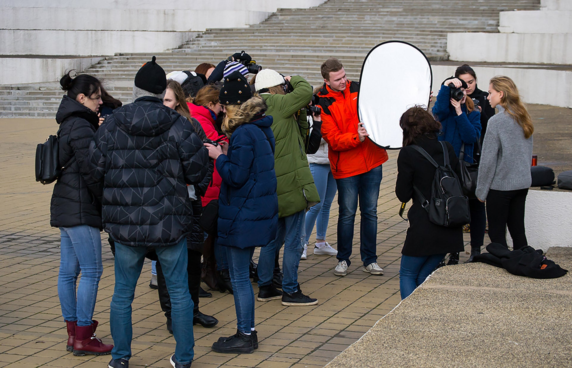 Group of amateur photographers learning how to shoot a model