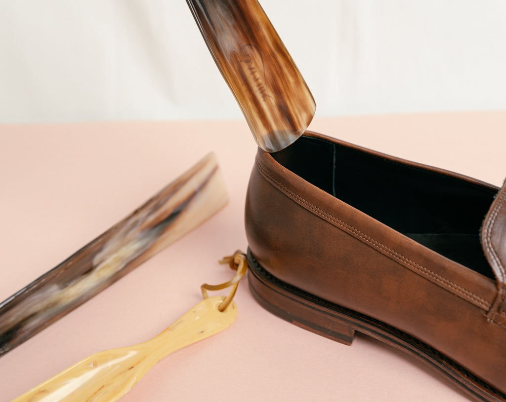 Close up of Saphir Natural Buffalo Horn shoe horn being used on a pair of Allen Edmonds