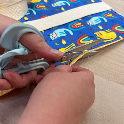 close up of trimming the fabric to make a french seam