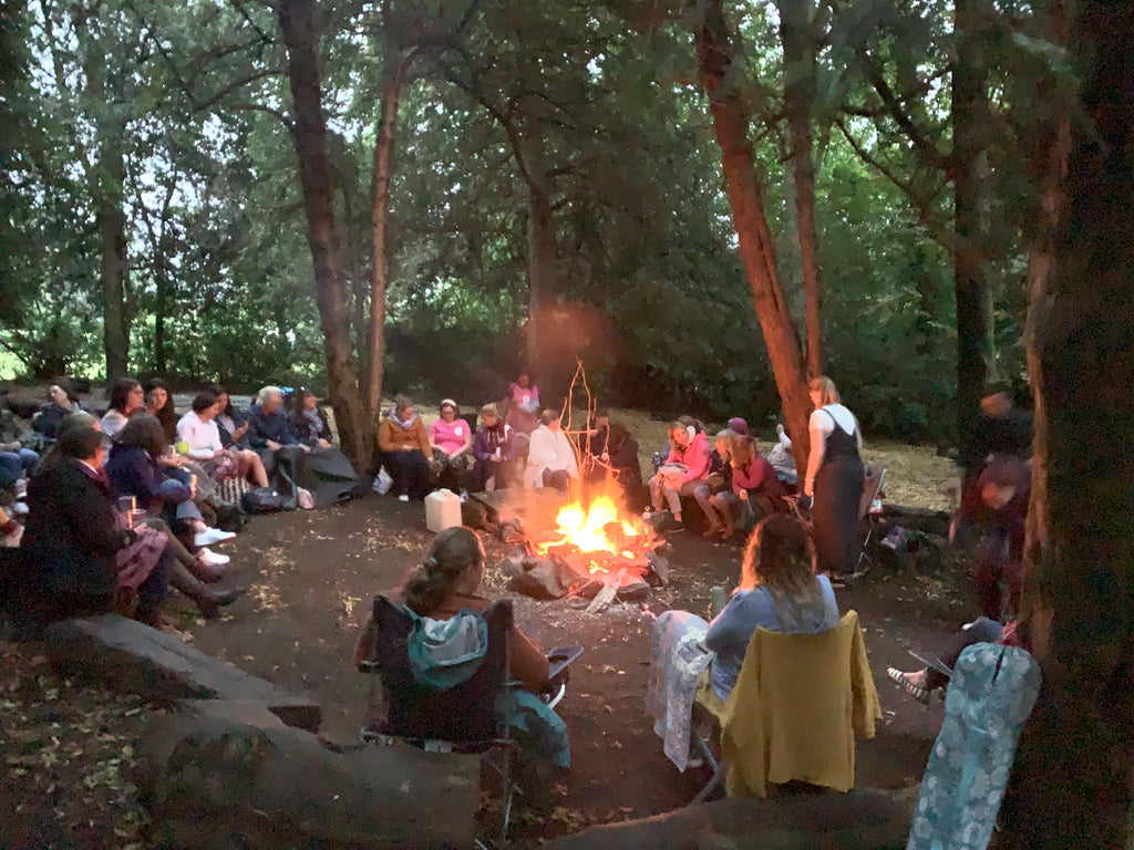 women sittand around a bonfire