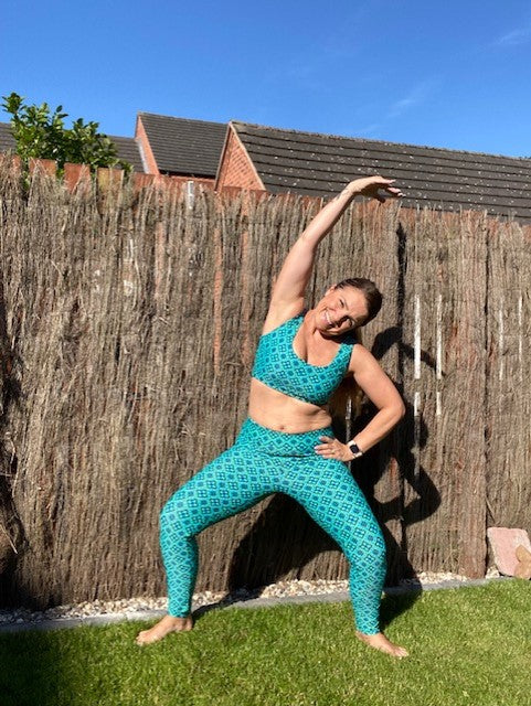 woman doing stretching exercises in an Action Pack crop top and leggings