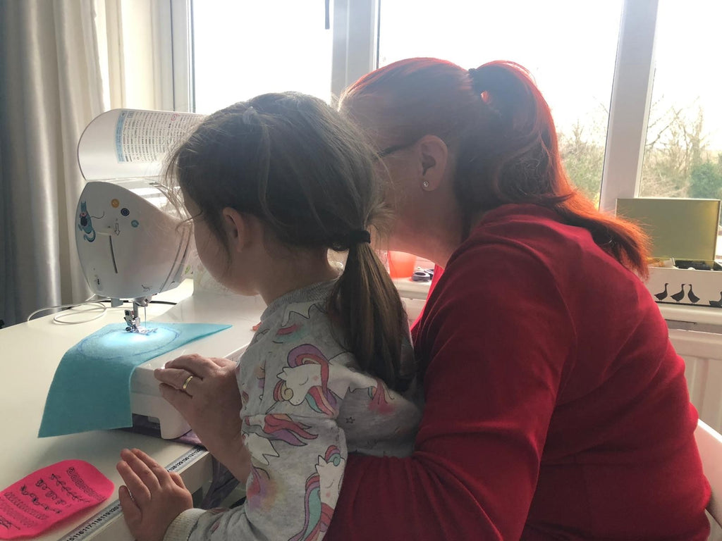 adult and child sewing at a sewing machine