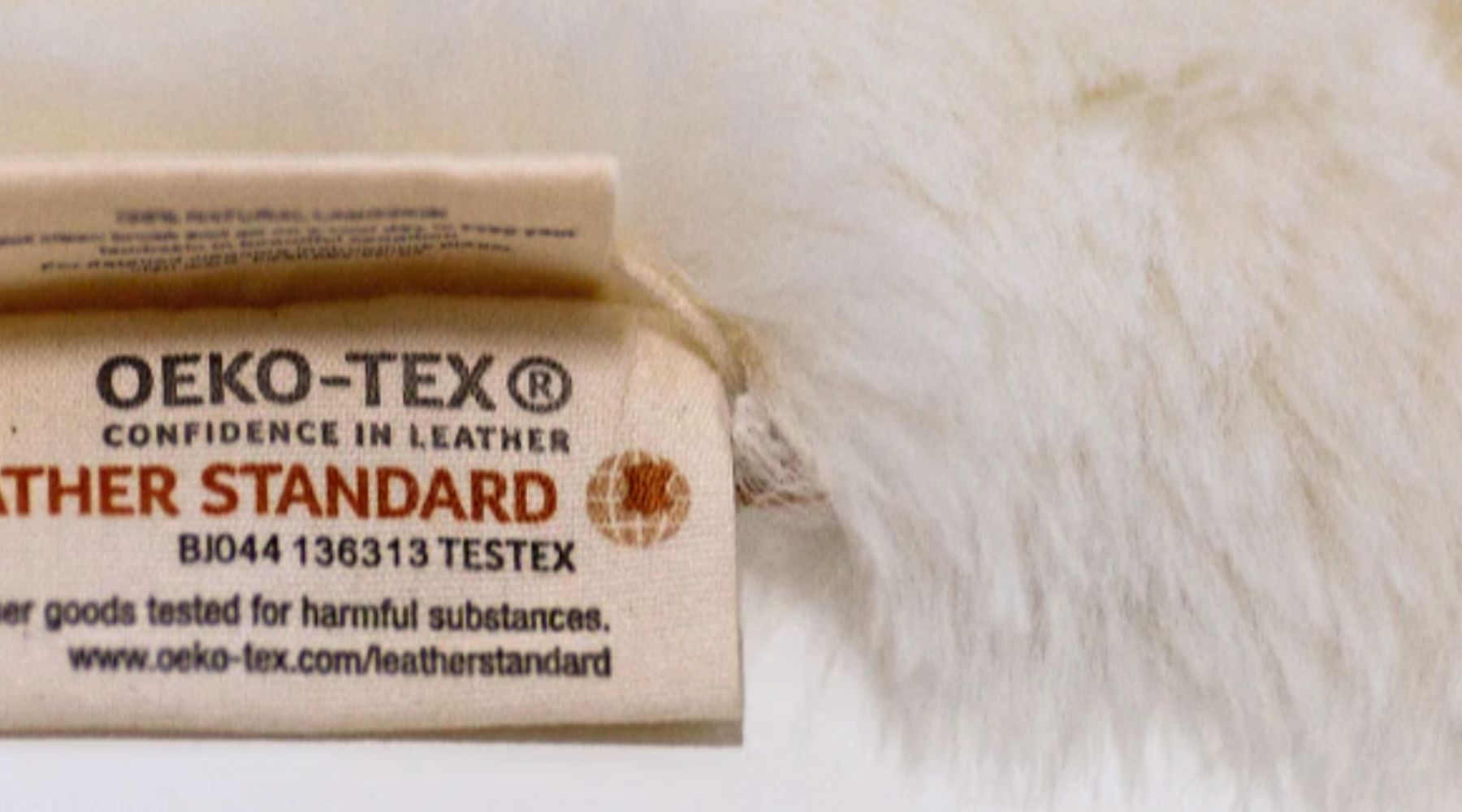 Zoom in on OKEO TEX certification label on sheepskin pram liner