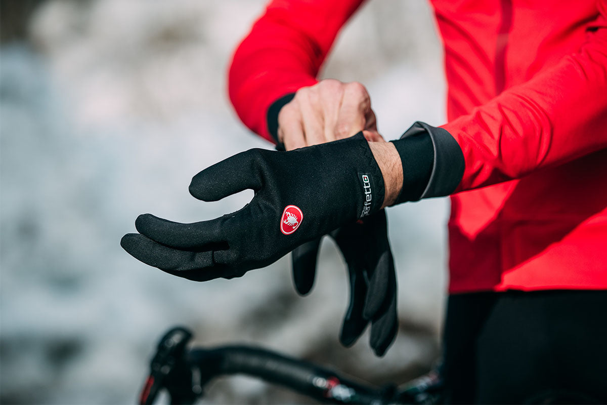 Cyclist in red jacket pulling on Castelli Perfetto RoS Gloves