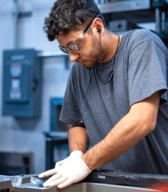 A man at ENVE HQ layering up carbon fibre parts