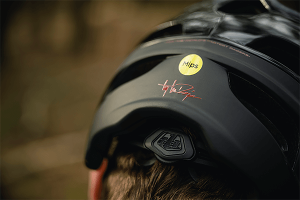 Back of the head of cyclist wearing a black Troy Lee Designs helmet 