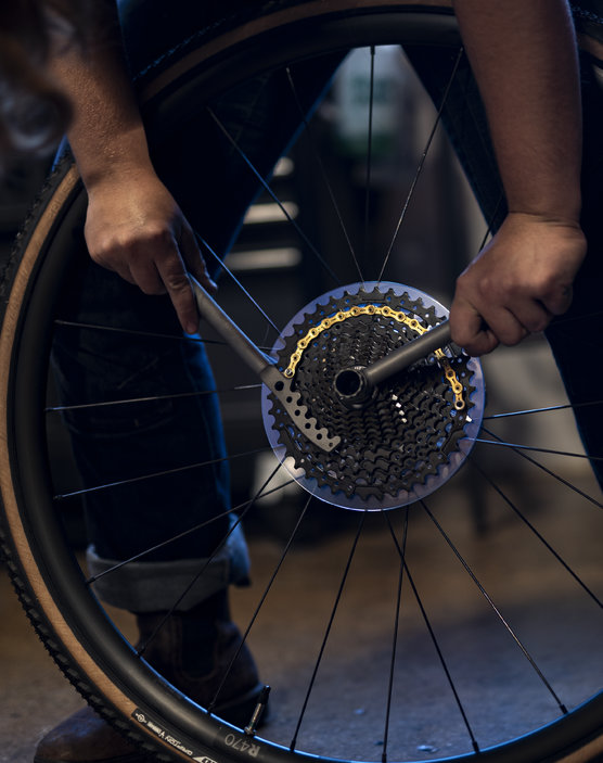 A man using a Silca 3D Printed Ti Lock Ring Tool to loosen a cassette