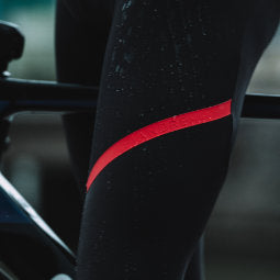 Closeup of the thighs of a male cyclist standing over bike wearing Fiandre NoRain Team Bib Tights