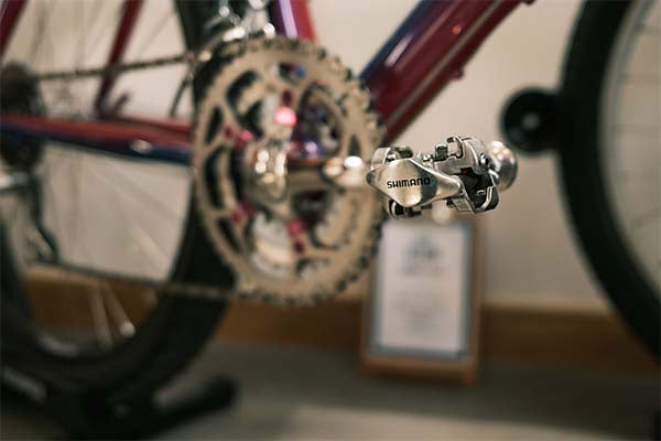 A closeup of the lower part of a Klein bike with Shimano pedals 