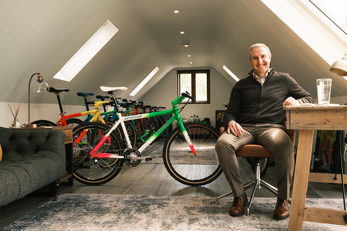 Andy Wigmore sits on chair in attic room with his 90s Klein bikes collection