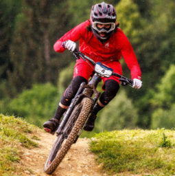 Male cyclist riding at 2022 Enduro World Series Round 2 wearing Troy Lee Designs knee guards