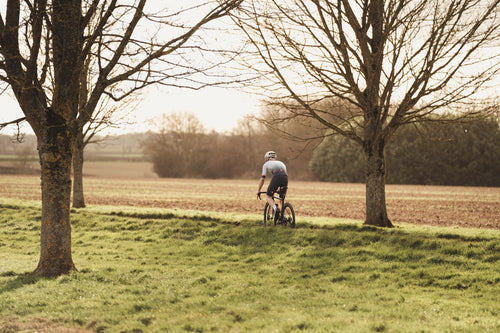 Rider wearing Castelli bib shorts riding along tree lined road