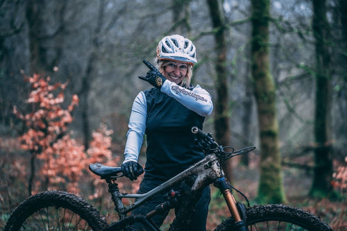 Female cyclist wearing the women's specific Troy Lee Designs Lilium Jersey and doing a 'rock on' hand gesture