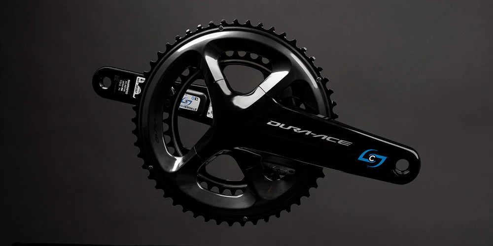 A Stages Cycling power meter shown against a grey background