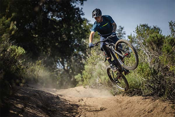 Cyclist in wood getting some air in Skyline Air kit