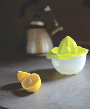 halved lemon in front of hand juicer