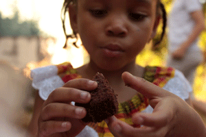 young girl holding chocolate muffin
