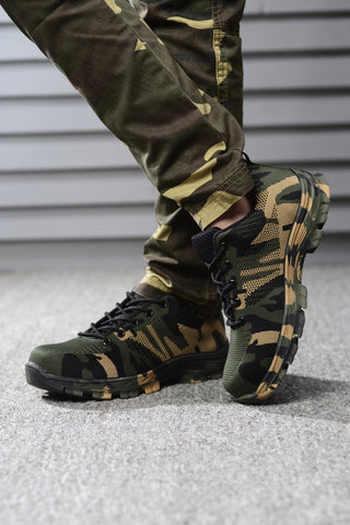 Person crossing legs wearing traditional camouflage Soldier shoes