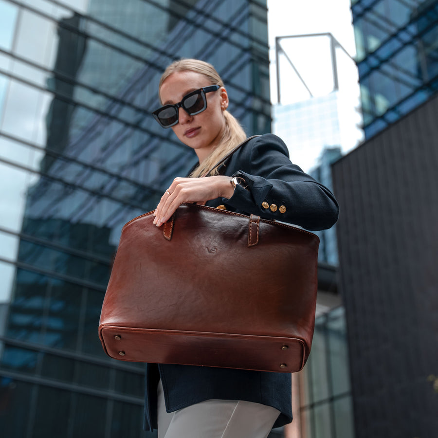https://cdn.shopify.com/s/files/1/2726/4990/files/von-baer-womens-large-leather-tote-bag-brown-on-female-model-business-style.jpg?v=1695720540&width=900