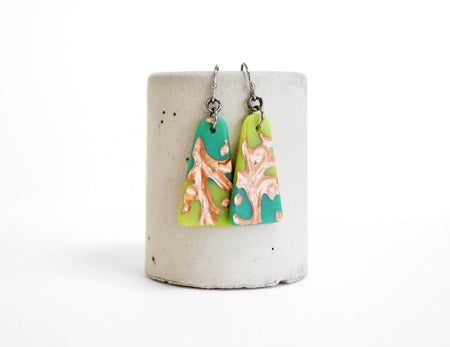 Green flat triangle dangle earrings handmade in glass by Leila Cools. Mismatched colorblock earrings with art nouveau style vine design in gold.
