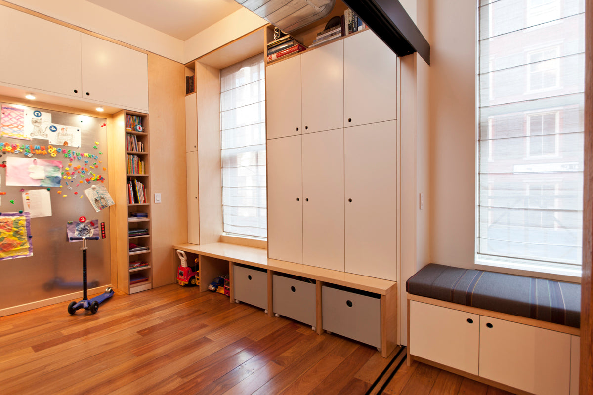 Modern child’s room with white cabinets, window seat, and colorful decor