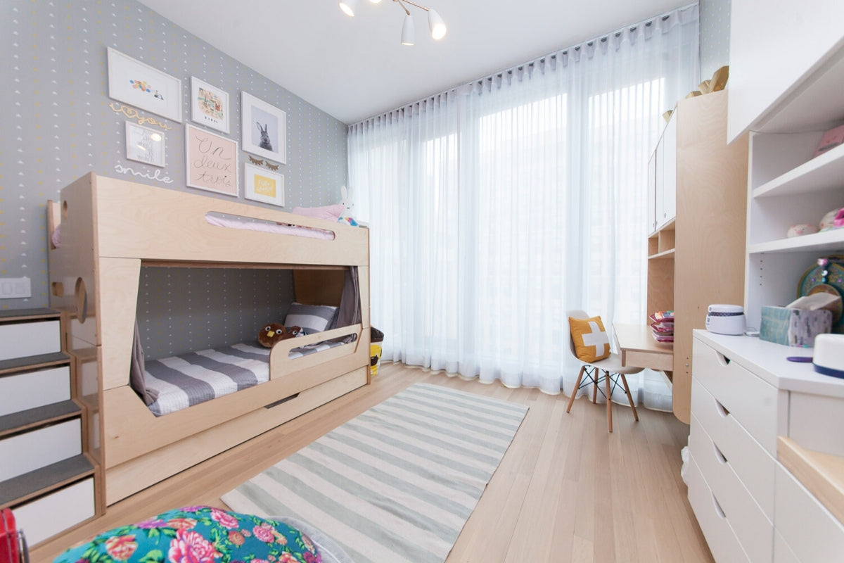 Neat children’s room with bunk bed, desk, and bookshelf.
