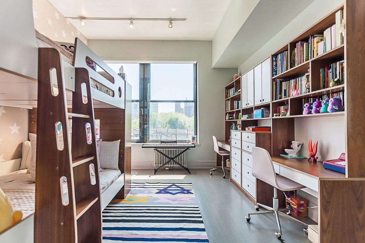 Modern study room with desk, shelves, and window view.