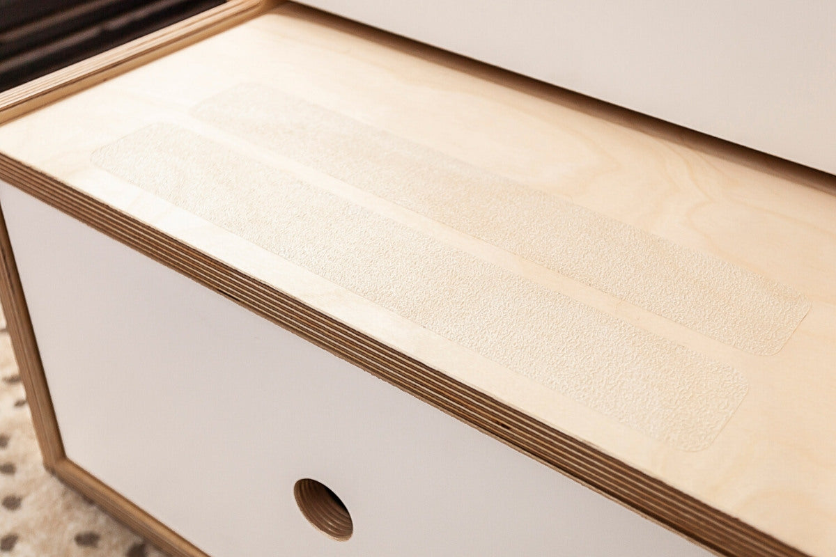 Wooden drawer with non-slip liner and round knob.